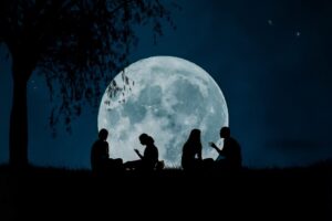 Two couples undera full moon at night represents relationship astrology.