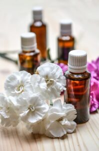 Pink and white flowers with essential oil bottles
