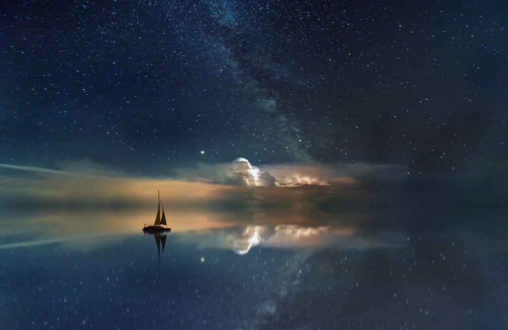 A boat looks for its way at night as a symbol for the north node and life purpose.