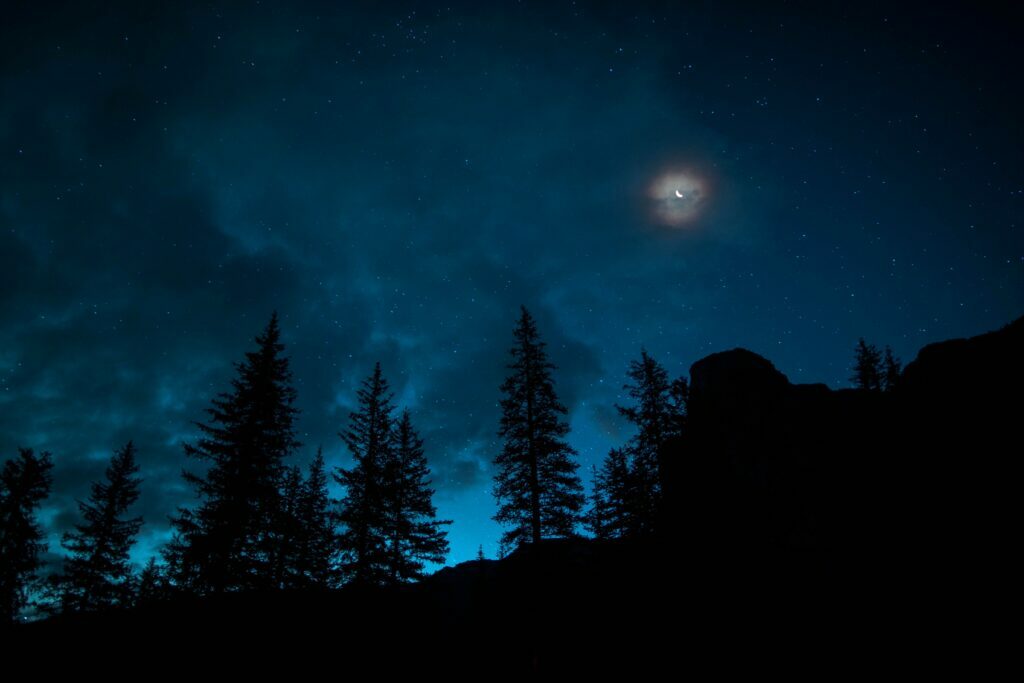 The stars and moon at night over a home symbolizes emotional healing with Pluto Moon and Dream Work.